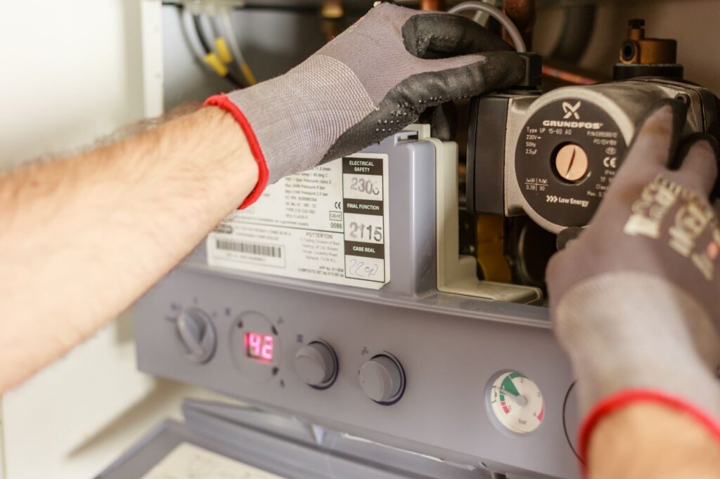 The Art of Drawing Readers In: Your attractive post title goes here Close-up of hands adjusting a boiler system with precise instrumentation, showing maintenance work.